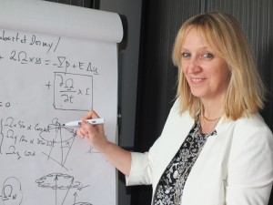 Véronique Dehant before a board filled with Earth rotation equations. 