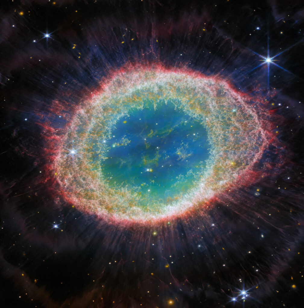De ruimtetelescoop James Webb van NASA toont de bekende Ringnevel in ongekend detail. De Ringnevel wordt gevormd door een ster die zijn buitenste lagen afwerpt wanneer zijn brandstof opraakt en is daarmee een archetypische planetaire nevel. Dit nieuwe beeld van NIRCam (Near-Infrared Camera) van de telescoop James Webb toont fijnmazige details van de filamentstructuur van de binnenste ring. Er zijn zo'n 20.000 globules met een hoge dichtheid in de nevel, die rijk zijn aan moleculaire waterstof. De binnenste regio bevat daarentegen zeer heet gas. De hoofdschil bevat een dunne ring met emissie van koolstofhoudende moleculen die bekend staan als polycyclische aromatische koolwaterstoffen (PAK's). Download de volledige resolutieversie van het Space Telescope Science Institute. Copyright: ESA/Webb, NASA, CSA, M. Barlow (University College London), N. Cox (ACRI-ST), R. Wesson (Cardiff University).