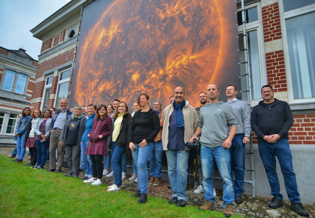 Photo de personnes devant une immense image du Soleil