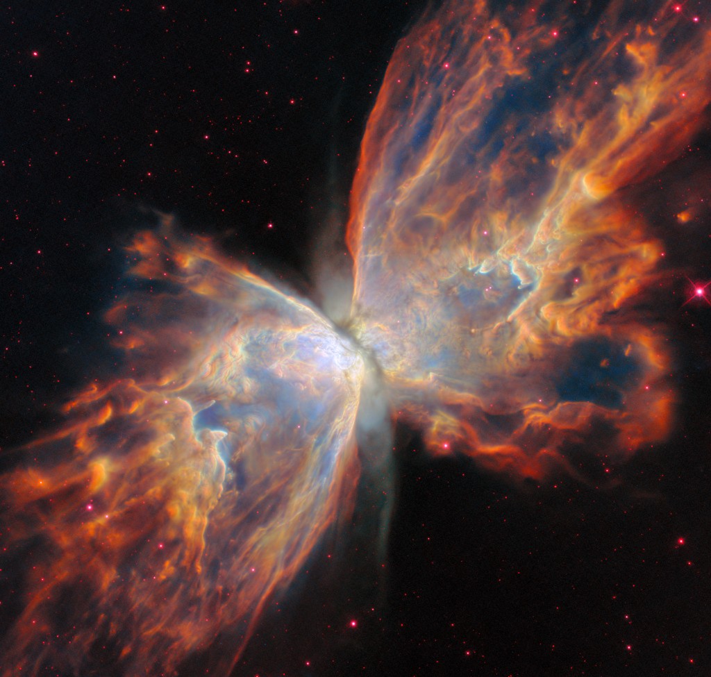 Photo de la nébuleuse du Papillon, un objet stellaire qui semble avoir deux ailes et un corps étroit, d'où son nom. Les ailes sont comme des flammes de couleur rouge et bleue, le corps est de couleur bleutée.