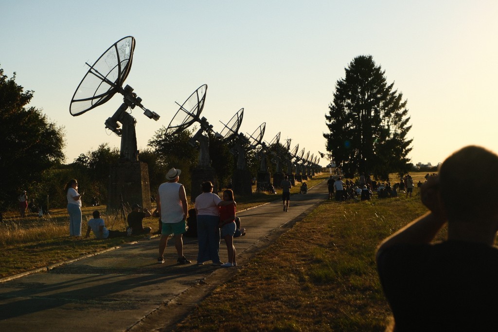 Een menigte naast een rij antennes die naar de hemel kijkt. 